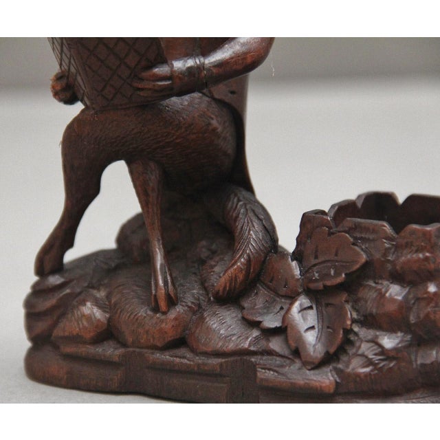 A lovely ornate 19th Century black forest carving of a fox, sitting cross legged reading a book, the fox wearing a jacket...