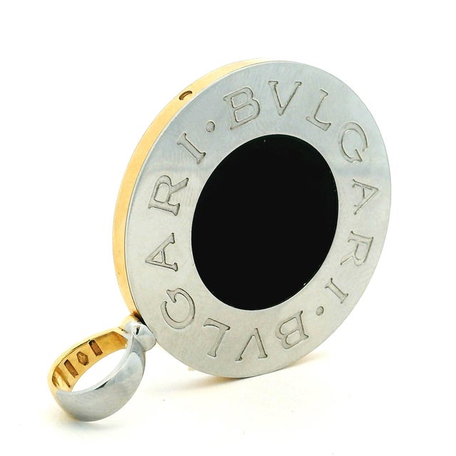 A large reversible Bulgari Bulgari pendant in 18K yellow gold and stainless steel. One side features luminous mother-of-...