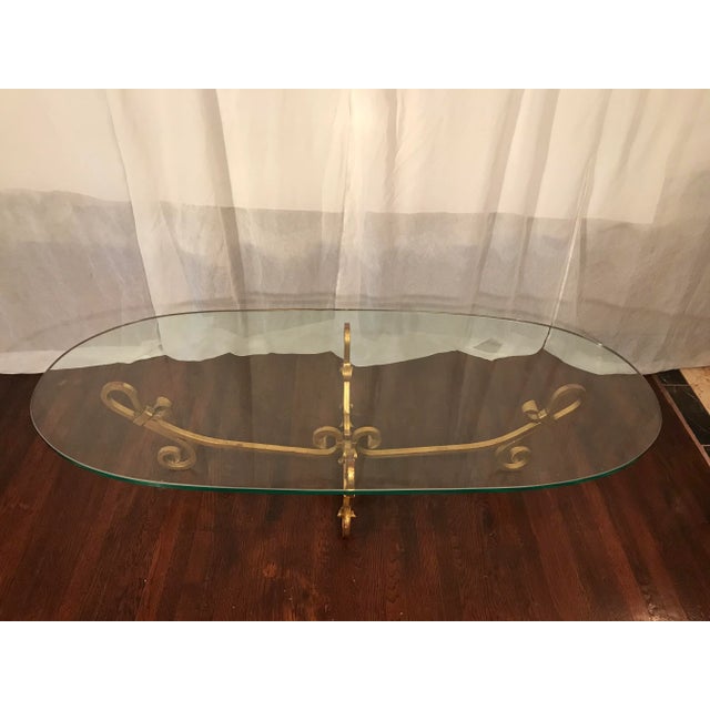 Gorgeous very large gilt wrought iron Hollywood Regency cocktail table. Styled after Gilbert Poillerat. This elegant long...