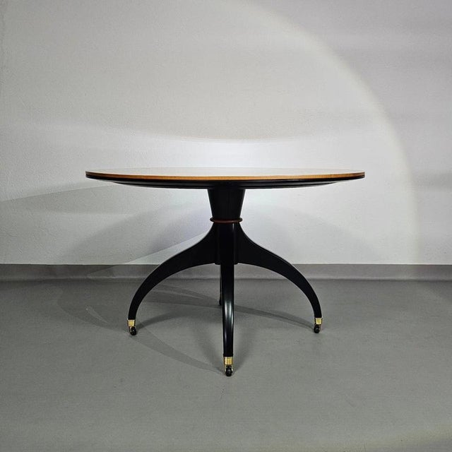 Circular table signed Giorgetti from the 80s Centro Ricerche. Matt black lacquered base and brass wheels to facilitate...