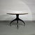 Circular table signed Giorgetti from the 80s Centro Ricerche. Matt black lacquered base and brass wheels to facilitate...