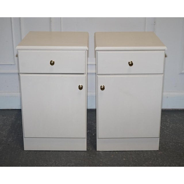 Antiques of London This pair of white bedside cabinets blends sleek design with practical storage — ideal for modern or...