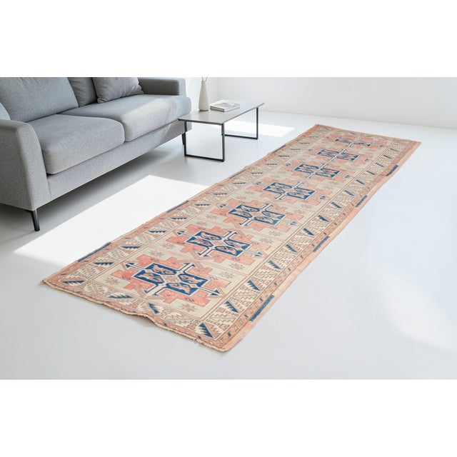 This is a vintage Turkish Oushak rug from the Mid 20th Century. The piece was hand-knotted.