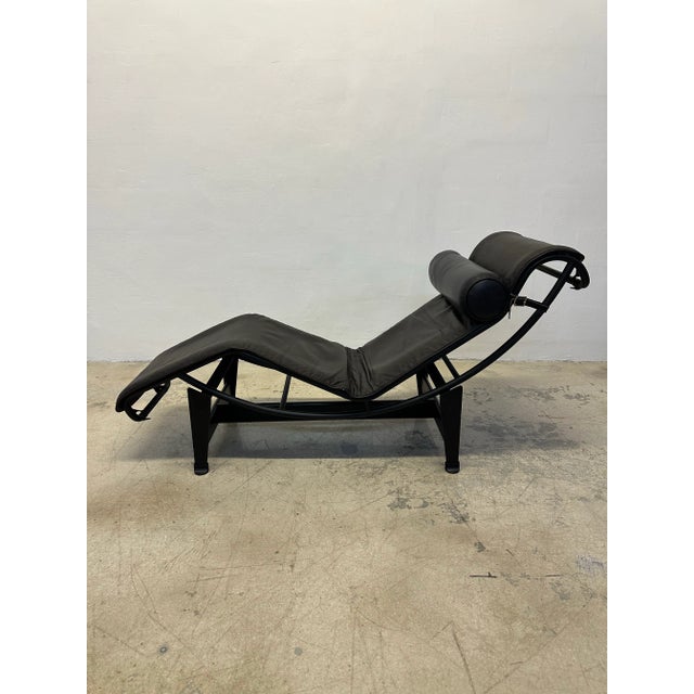 Dark Brown leather LC4 Noire chaise lounge with Black leather bolster pillow on black tubular steel and black steel base...