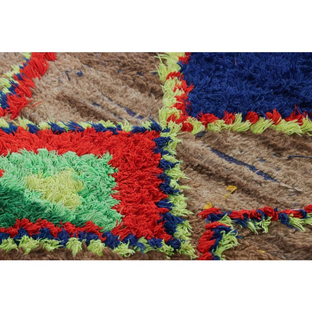 Hand-knotted in wool and originating from Morocco circa 1950-1960, this 2x9 vintage runner rug is a rare and among the...