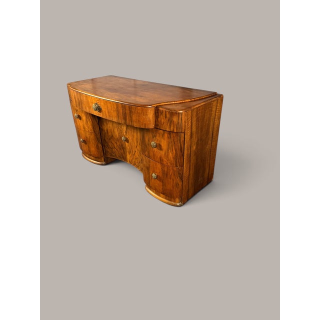 An elegant Art Deco desk from the 1930s, featuring the softly rounded lines typical of Streamline Moderne. The compact...