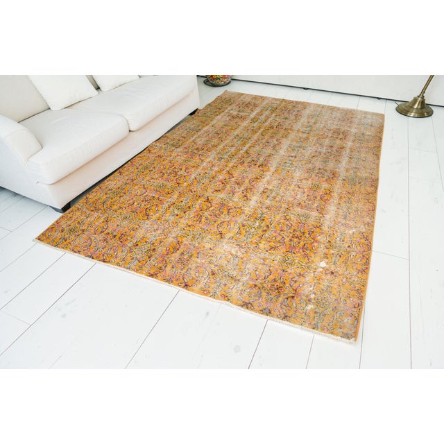 This is a vintage Turkish Oushak rug from the Mid 20th Century. The piece was hand-knotted.