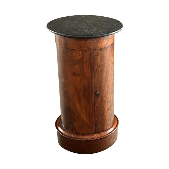 Dimensions: 28 ⅜” H x 16 ⅛” W x 16 ⅛” D A columnar, French mahogany and marble top bedside table that offers both storage...