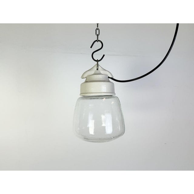 Vintage industrial light made in former Czechoslovakia during the 1970s. It features a white porcelain top and a glass...