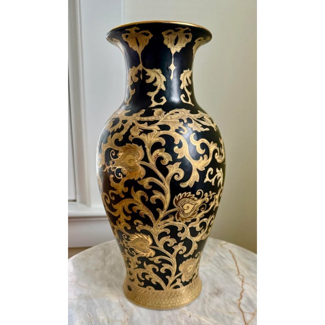 Gorgeous vintage Chinese vase showcasing a gold vine and leaf design against a dramatic black background. Unique and...