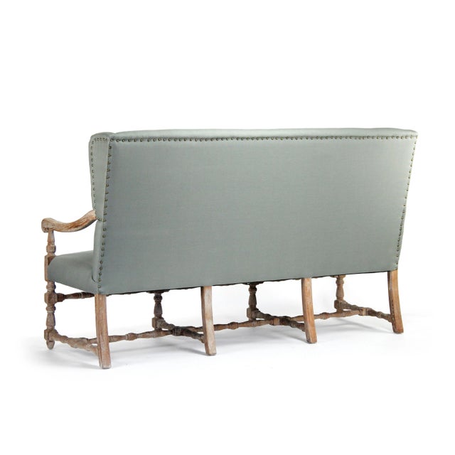 Wing back bench upholstered in sage linen on limed grey oak frame.
