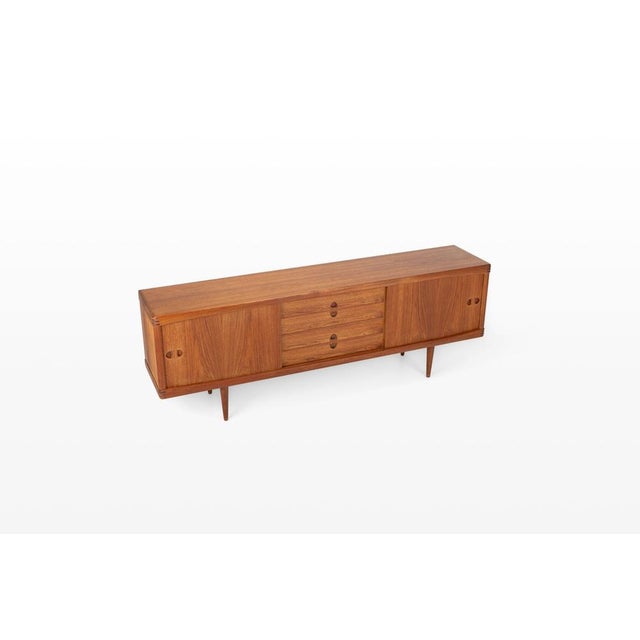 A refined example of scandinavian craftsmanship from the 1960s, this vintage teak sideboard was designed by henry w. Klein...