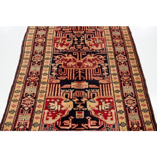 This hand-knotted wool rug features a dark blue field with an all-over design and peach accents. This rug measures 3'5'' x...