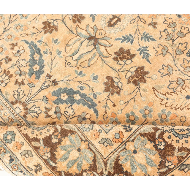 An early 20th century Persian Meshad (Meshed) antique carpet, the abrashed caramel field with an allover design of...