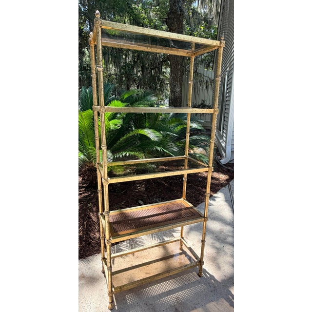 Fancy Italian gold-gilt faux bamboo and glass étagère featuring pineapple decorative finials. 4 smoked glass shelves as...