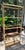 Fancy Italian gold-gilt faux bamboo and glass étagère featuring pineapple decorative finials. 4 smoked glass shelves as...