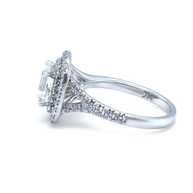 This exceptional GIA certified emerald cut diamond cluster ring is masterfully crafted in 18ct white gold, showcasing a...