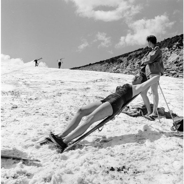 Sunbathing Skier circa 1956: With the temperature at around 80?, a skier reclines on her propped up skis and sunbathes in...