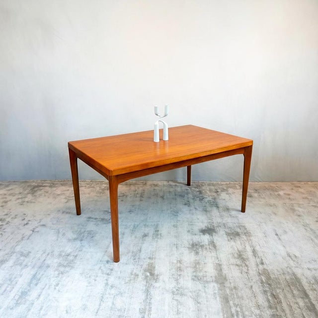 Constructed in solid teak throughout. The tabletop features softly rounded corners with sculpted detailing beneath the...