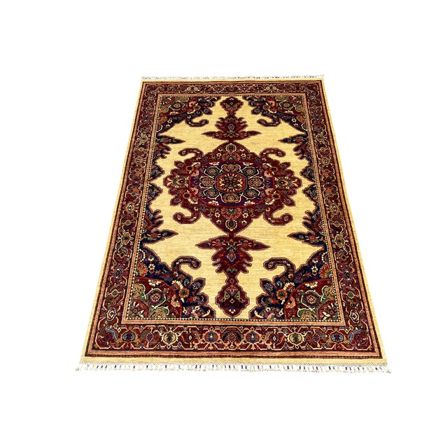A richly detailed central medallion anchors this natural-dyed wool rug. Deep red, navy, and subtle green motifs stand out...