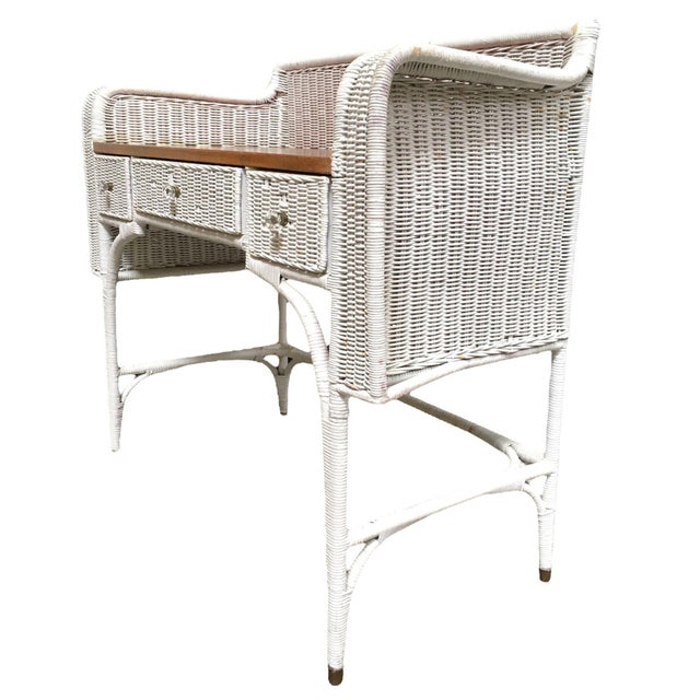 Mid-century white wicker writing desk with Mahogany wood desktop and matching chair. The desk features three woven drawers...