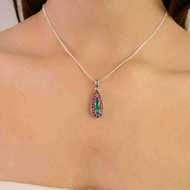 Handcrafted in 925 sterling silver, this pendant showcases a stunning combination of emerald and ruby gemstones in oval...
