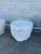 A pair of contemporary sculptural side tables featuring abstracted human faces carved in relief against substantial...
