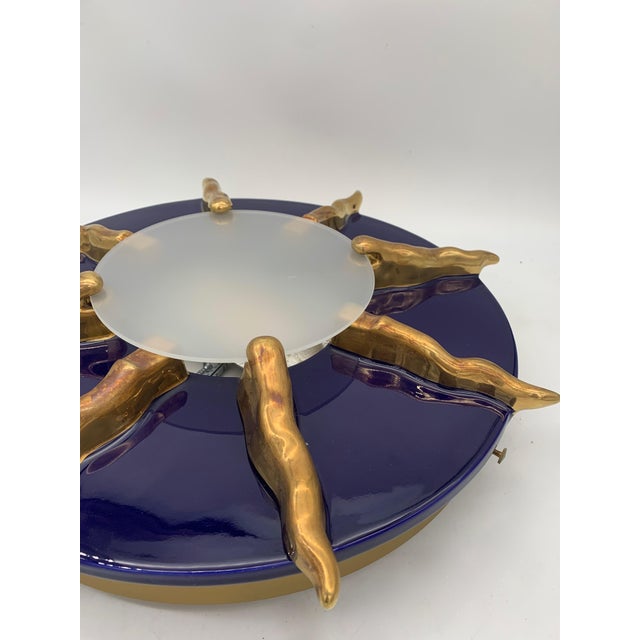 This lamp can be installed as a wall or ceiling light. It features an iconic sunray shape. At the center, a circular...