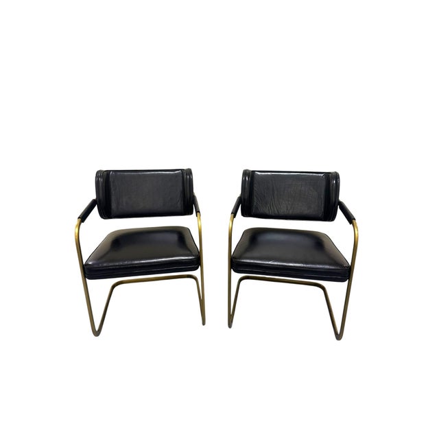 A pair of Jimmy Cooper Leather Armchairs by Industry West, offered in black buffalo leather over a brushed brass...
