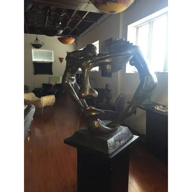 Stunning faux bronze resin sculpture called "We Two Together" depicting a man and a woman holding hands. The front forms a...