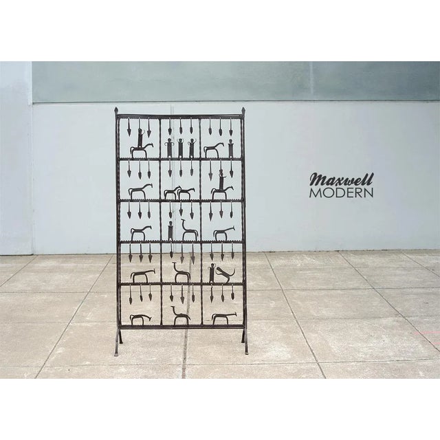 This is an incredible one-of-a-kind, modernist hand-forged iron screen in the manner of Frederic Weinberg. The primitive-...