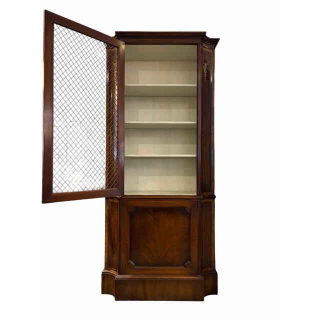 A refined mahogany display cabinet featuring a distinctive mesh-front design that blends traditional craftsmanship with a...