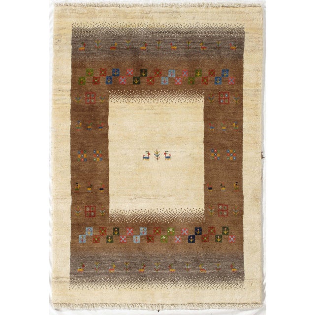 Vintage Persian hand-knotted Lori Gabbeh wool rug with an ivory field and a wide brown border with multicolored tribal...