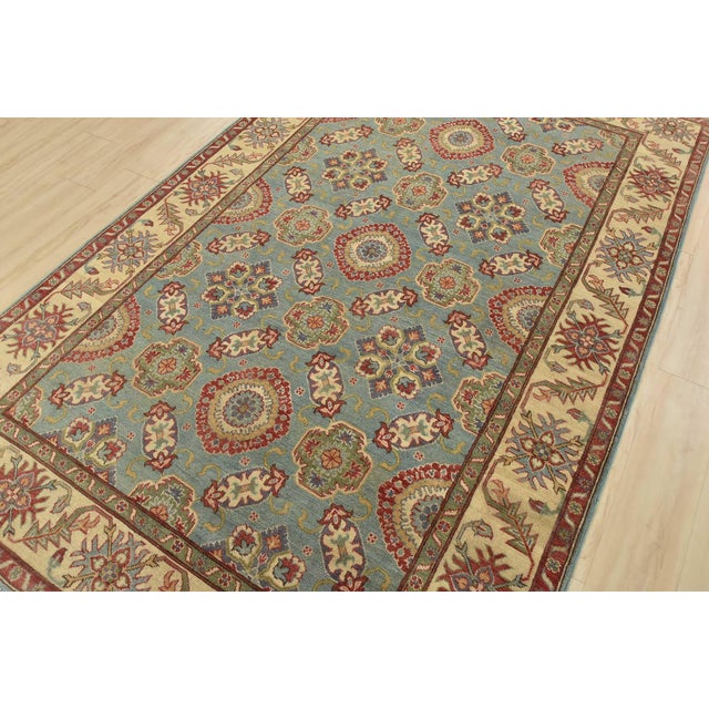 This traditional tribal geometric Caucasian Kazak rug is hand-knotted with an all-wool pile on a cotton foundation. This...