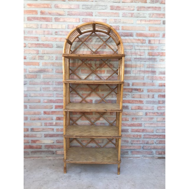 About Midcentury bamboo bookcase étagère, in the style of Maison Baguès. Handsome bamboo with five bamboo glass shelves in...