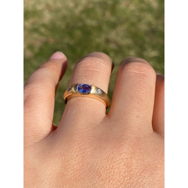 The Hereford: New Old Stock Vintage Tanzanite and Diamond Ring in Yellow Gold. This vintage-inspired ring, new from our...