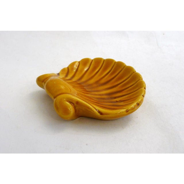 Scallop shell-shaped trinket dish with a striated design. Can be hung for wall decoration. Made of slip-cast earthenware...