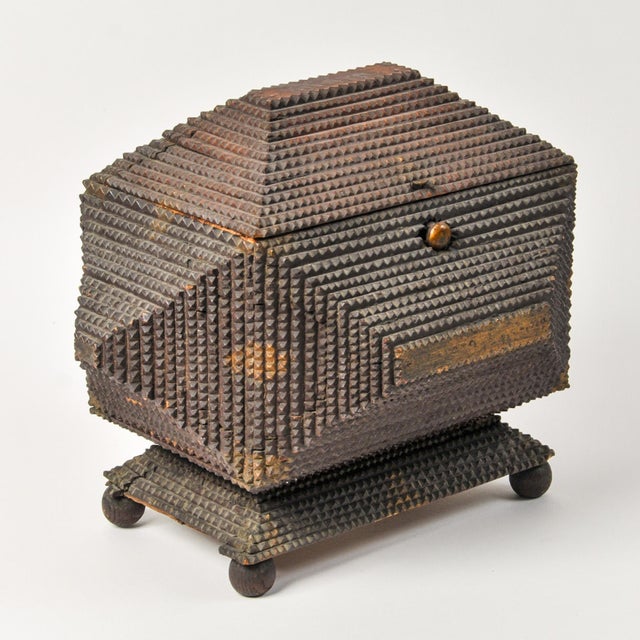 An incredible example of American folk art this large tramp art box features four round feet that the base pedestal sits...