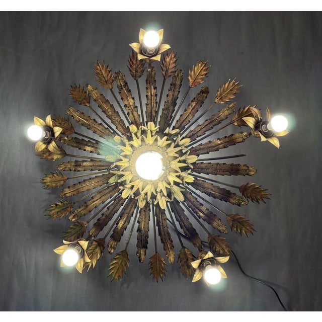 Ceiling lamp. Made in Spain in the 1950s. Features floral motifs and is made of iron with a gold finish. Total dimensions:...