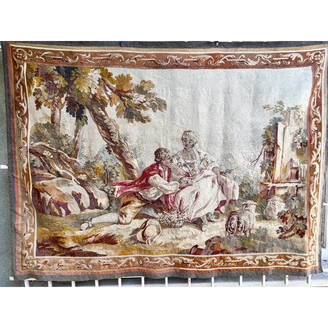 This elegant 19th-century silk tapestry depicts a couple in a lush garden setting. The composition features the figures...