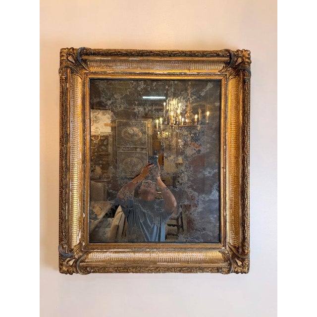 A beautiful French Louis Philippe mirror featuring a richly molded giltwood frame with elegant hand-carved detailing and...