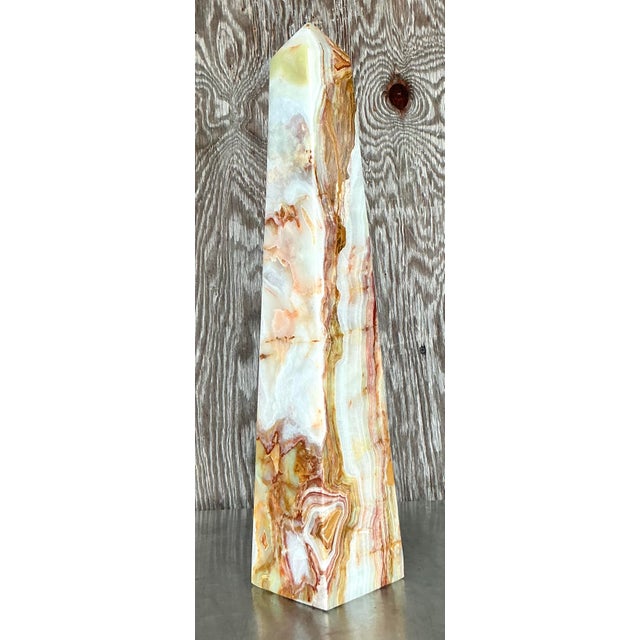 This striking vintage onyx obelisk is a breathtaking statement piece, showcasing natural swirls of cream, caramel, and...