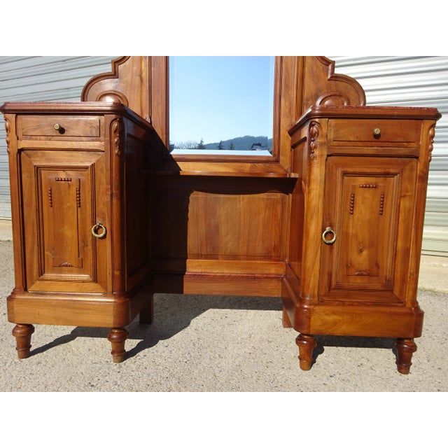 Solid walnut dressing table in the Louis XVI style. Large mirror rounded in the upper corners, beveled. Surrounded by two...