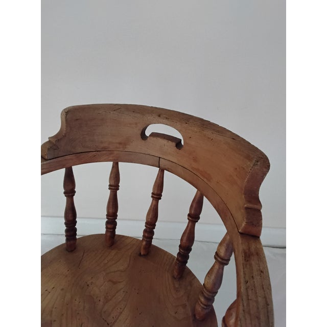 A Captains Chair made in Elm and Ash. Quite the rare model with 11 spindles, twin front stretcher rails, butlers grasp and...