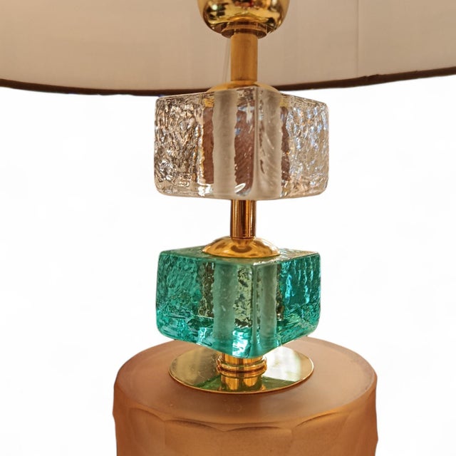 An exquisite pair of table lamps with a unique design. An elongated Murano glass cylinder with an opaque finish and a warm...
