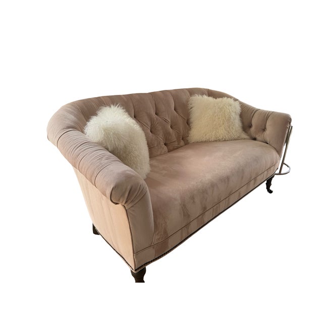 This romantic tufted loveseat features a curved back and rolled arms, upholstered in soft blush velvet with subtle sheen....