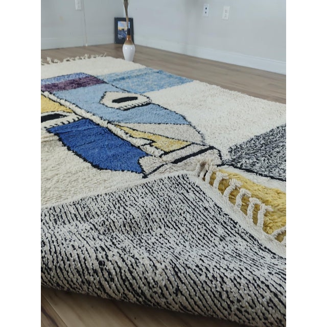 An abstract cubist portrait hand-knotted in wool by Moroccan Berber artisans - fractured, geometric facial planes in...