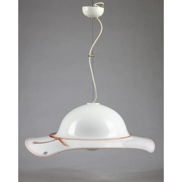 Glass pendant chandelier in the shape of a wide-brimmed ladies hat decorated in pink glass on the rim and cord. Murano...