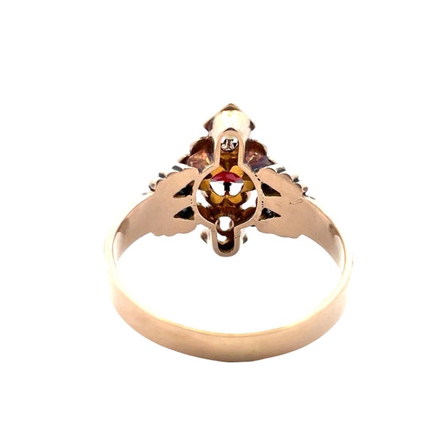 Elegant vintage ring crafted in 14K yellow gold, featuring a rich garnet center stone accented by two delicate seed...