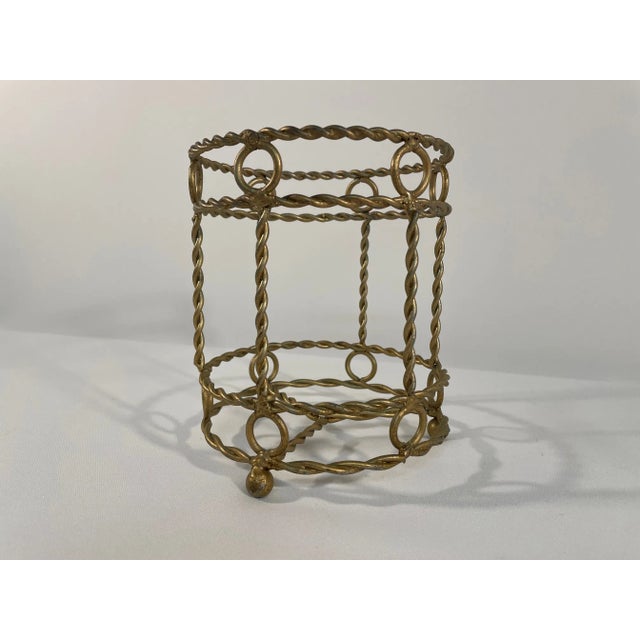 A lovely Gold Twisted Metal rope design Wine Bottle Holder. Circa 1970s. This whimsical holder easily accommodates a wine...